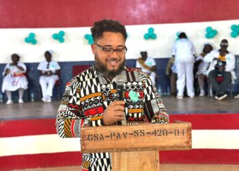 An American-Liberian doctor speaks to students during a career day program at a school event in Liberia.