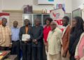Officials from the Liberia Telecommunications Authority present a mobile money operating license to representatives of Vita Money in Monrovia.