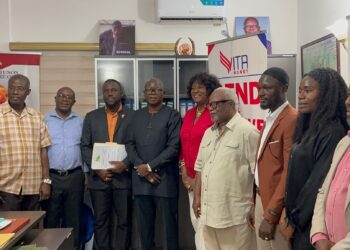 Officials from the Liberia Telecommunications Authority present a mobile money operating license to representatives of Vita Money in Monrovia.