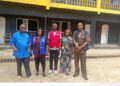 Officials from the Liberia Revenue Authority, Ministry of Education and WAEC pose during a school compliance enforcement exercise.