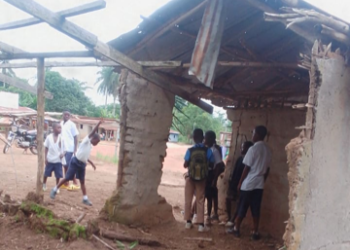 Students sit inside a dilapidated mud hut in Borkeza Junction, Zorzor District, after a fire destroyed their only elementary school in Lofa County.