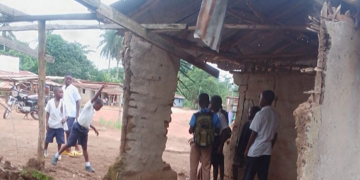 Students sit inside a dilapidated mud hut in Borkeza Junction, Zorzor District, after a fire destroyed their only elementary school in Lofa County.