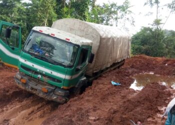 A truck stuck in deep mud on a damaged road in Grand Gedeh County, southeastern Liberia.