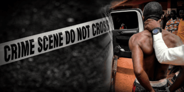 Liberia National Police officers escort murder suspect Richard Denteh following his arrest in Bong County.