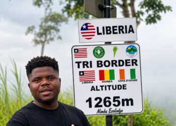 Ghanaian YouTuber Wodemaya standing at the Liberia-Guinea-Ivory Coast tripoint in Nimba County.