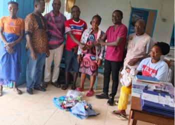 Edwin Kidjlay presents medical supplies to residents of Buah Statutory District in Grand Kru County.