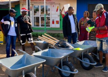 Assistant Labour Minister Jackson F. Wolobah donates community development supplies during an outreach program in Zorzor, Lofa County.
