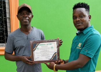 LDEA Deputy for Operations Momodu Kiadii receives the Officer of the Year award from Clean Communications Network–Liberia.