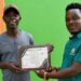 LDEA Deputy for Operations Momodu Kiadii receives the Officer of the Year award from Clean Communications Network–Liberia.