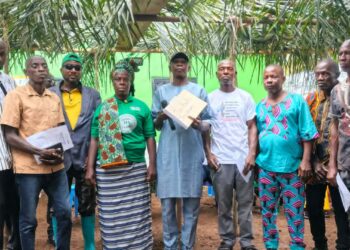 Officials of the Liberia Land Authority present a customary land deed to residents of Karzah Section in Lofa County.