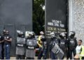 riot police officers stand at the entrance of the Monrovia Central Prison