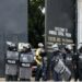 riot police officers stand at the entrance of the Monrovia Central Prison