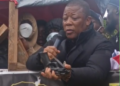 STAND chairman Mulbah K. Morlu displays a firearm during the July 17 protest in Monrovia.