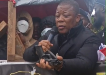 STAND chairman Mulbah K. Morlu displays a firearm during the July 17 protest in Monrovia.