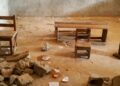 Students at J.F. Clarke Elementary School sit on damaged chairs and cement blocks during class