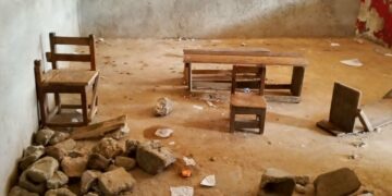 Students at J.F. Clarke Elementary School sit on damaged chairs and cement blocks during class