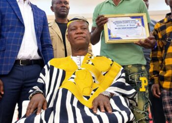 An elder presents Sen. Samuel Kogar with a traditional rod during a ceremony in Nimba County