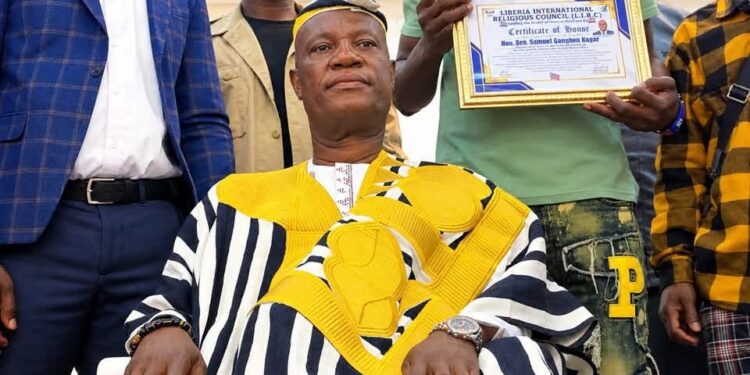 An elder presents Sen. Samuel Kogar with a traditional rod during a ceremony in Nimba County