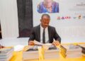 Architect Edmond Lloyd displays his book “Lines of a Nation” during its launch at Monrovia City Hall