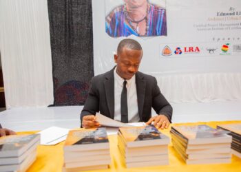 Architect Edmond Lloyd displays his book “Lines of a Nation” during its launch at Monrovia City Hall