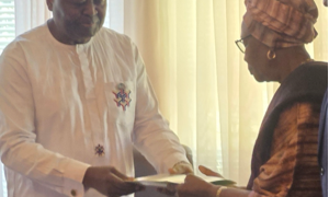 Ambassador Al-Hassan Conteh presents Rev. J. Edwin Lloyd Sr.’s posthumous award to his widow, Emma Mitchell Lloyd