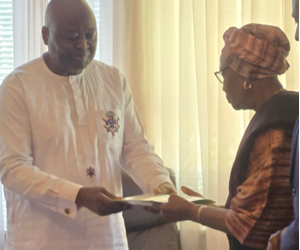 Ambassador Al-Hassan Conteh presents Rev. J. Edwin Lloyd Sr.’s posthumous award to his widow, Emma Mitchell Lloyd