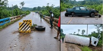 A damaged green sedan lying across the roadway at Janapita Bridge in Bong County.